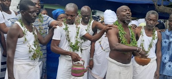 • Asafoatse Folly Kangni Mathias with calabash and Nii Ashitey Tetteh offering prayers while other family members look on