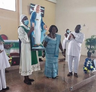 Madam Victoria Kponyoh (standing in the middle) while the Marian statue is raised forthe congregation to see. Standing right is Mr Peter Gagah