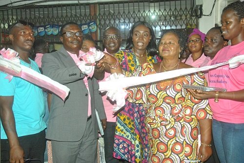 • Mr. Martin Adu-Owusu (right), MD, New Times Corporation, being supported by Mr. Emmanuel Amponsah (2nd left), Editor of The Spectator, Madam Dakoa Newman (3rd left), MP, Okaikoi South, and Madam Lydia Naa Kowah Quaye (4th left), Queen of Kaneshie Market Complex, to cut the ribbon