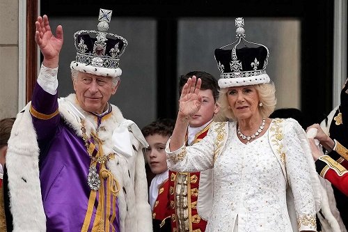 King Charles III and Queen Camilla wave the crowd after the ceremony