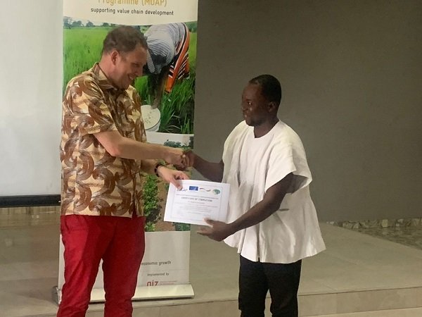 Deputy Head of Mission, European Union Delegation to Ghana Mr. Pieter Smidt Van Gelder (left) presenting a certificate to one of the beneficiaries.