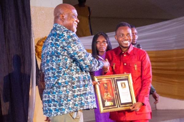 • Mr Hopeson Adorye receiving an award on behalf of wife, Empress Gifty