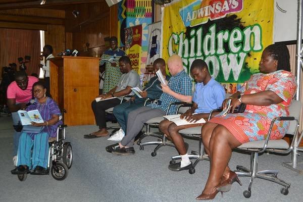 Some of the dignitaries and children reading a book at the programme Photo Victor A. Buxton