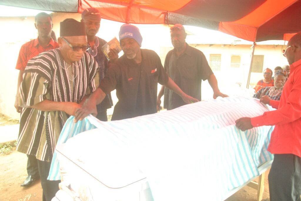 Removing the cloth from the coffin