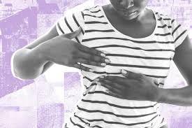 A woman examining her breast
