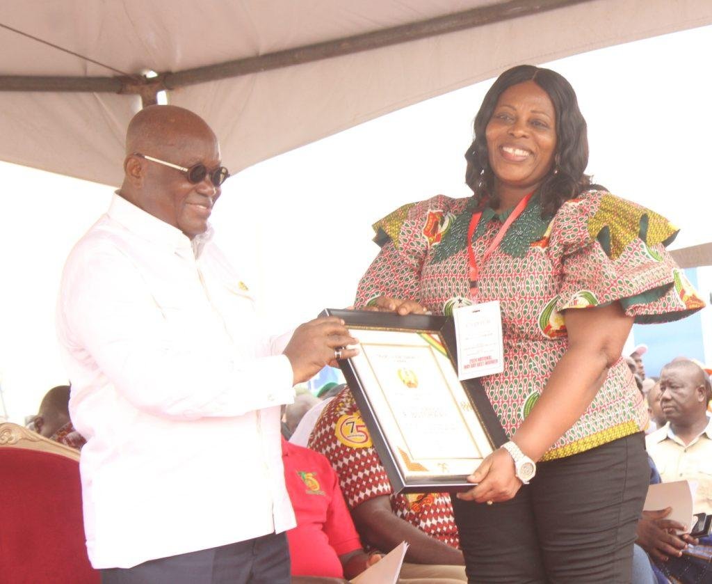 Mrs Harriet Botchway receiving award from President Akufo-Addo at the May Day celebration .
