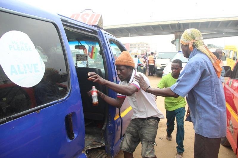 A popular loading boy at the Odawna trotro station happily going about his work