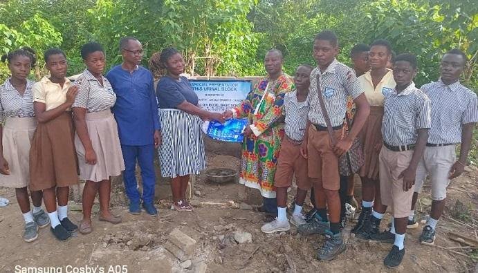 • Mr Isaace Okyere(right)presenting the keys to the facility to Miss Joyce Maneame with some of the pupils and staff looking on