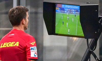 A referee conducting a video review with the aid of VAR to overturn or confirm a decision