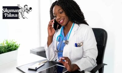 Smiling black woman speaking on smartphone in office