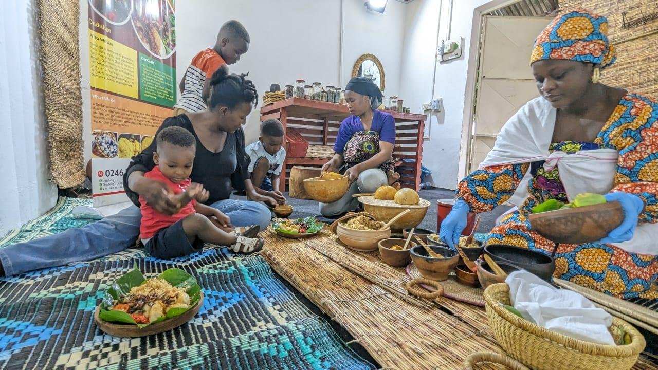Madam Amina Pagnaa (right) dishing some traditional food to guests at the Duduhgu Traditional Kitchen