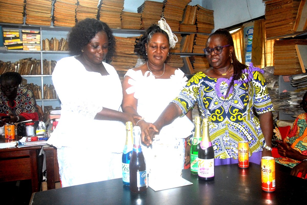 Mrs Georgina Quaittoo[right] the president of the ladies Association cutting the cake with Ms Mavis and Mrs Nartey