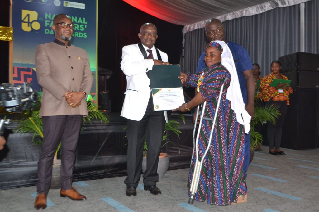 Ms. Ayisha Salifu (right) receiving from Mr. Simon Osei-Mensah(middle),Ashanti Regional Minister ,the Ashanti Regional Best Physically Challenged farmer award Photo Victor A. Buxton