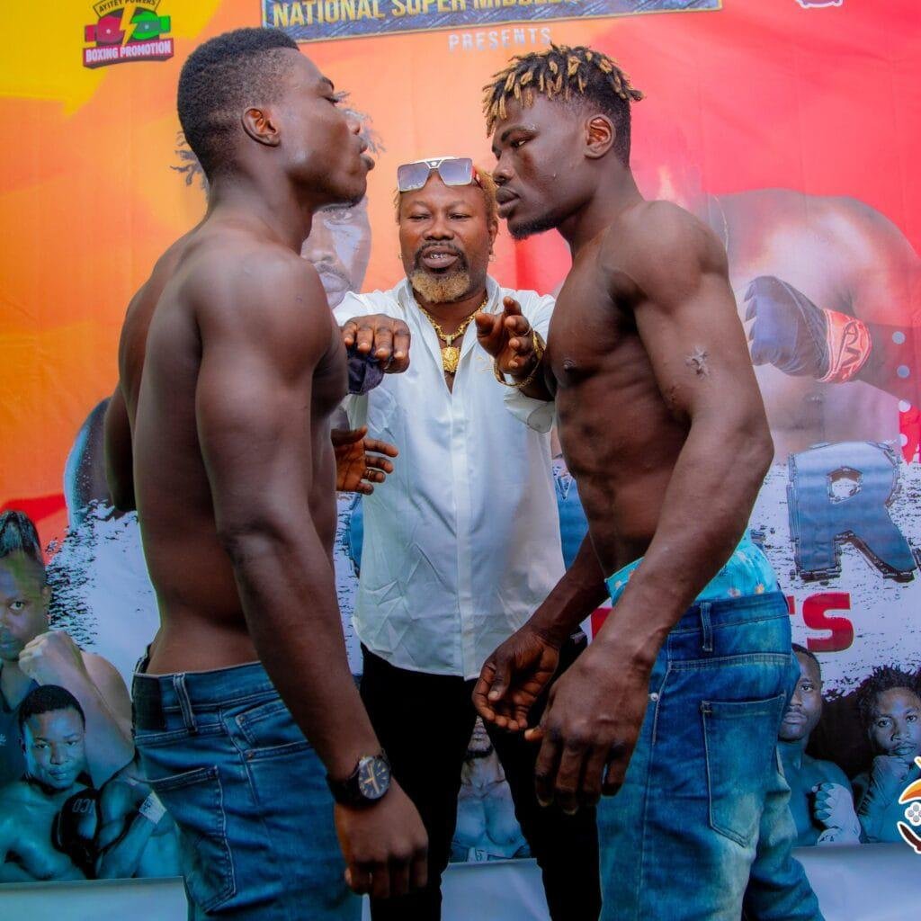 Ayitey Powers separates the two boxers, Elvis Aworgah (left) and Ernest Baubali at the weigh in ahead of their National Super Middleweight clash