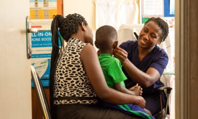 Florence Nabukeera, a medical clinical officer performing a physical examination to ensure good health of Ivan Wesige, while he is been carried by his mother Annet Nakayiza, during a child TB project at Kisubi Hospital in Entebbe, Uganda