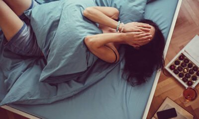 Depressed woman in bed with hands on face