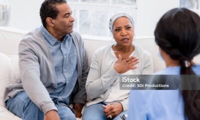 The senior woman holds her chest and talks to the nurse to describe the pain she has been having.