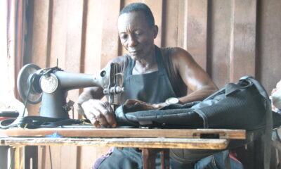 Mr Kofi Oduro sewing a bag to support the family