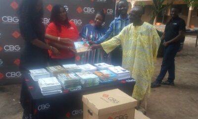 The MD of CBG , Dr Kwetey presenting the books to the Headteacher of Adaklu- Vodze Basic School, Mr Dzidza (second from right) supported by the School Management Committee Chairman