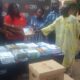 The MD of CBG , Dr Kwetey presenting the books to the Headteacher of Adaklu- Vodze Basic School, Mr Dzidza (second from right) supported by the School Management Committee Chairman