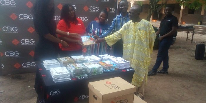 The MD of CBG , Dr Kwetey presenting the books to the Headteacher of Adaklu- Vodze Basic School, Mr Dzidza (second from right) supported by the School Management Committee Chairman