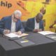 Mr Blewett (left) and Kurt Okraku append signatures to the deal