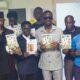 Mr Yaw Ampofo (left), launching the booklet, with him are Dr Blessing Ackah, Mr Darko-Mensah, and other dignitaries.