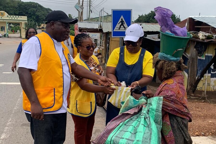 Members of the club giving food to a mental patient