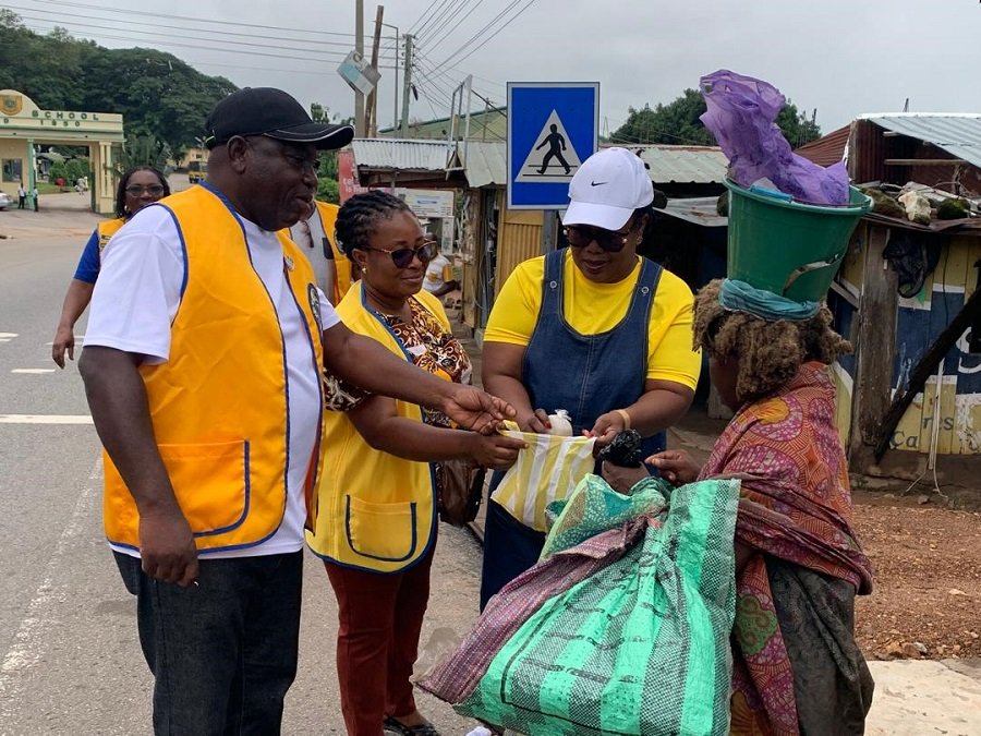 Members of the club giving food to a mental patient