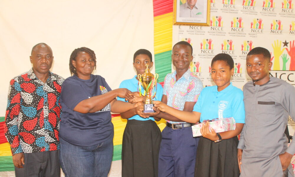 Mrs Gloria A. Kudo (left) Deputy Regional Director,NCCE, Greater Accra Region presenting the winner trophy to all Saints Anglican Model Basic school Photo: Ebo Gorman