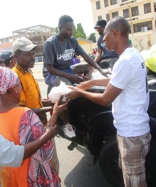 Mr Ransford Nii Antie Quaye (right) sharing sharing some food on the street