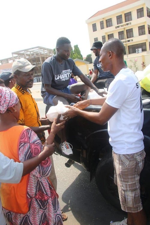 Mr Ransford Nii Antie Quaye (right) sharing sharing some food on the street