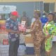 Rev Mensah (Left) presenting the items to DSP Joyce Adubea Tieku while others look on