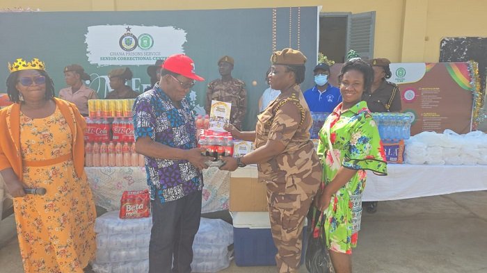 Rev Mensah (Left) presenting the items to DSP Joyce Adubea Tieku while others look on