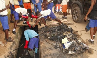 Some of the school children desilting choked gutters.