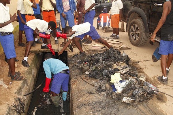 Some of the school children desilting choked gutters.