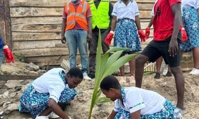 Some students planting a tree after clean up exercise
