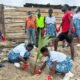 Some students planting a tree after clean up exercise