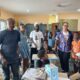 Dr Lartey (left) and Ms McGee with some of the children seating on the new desks
