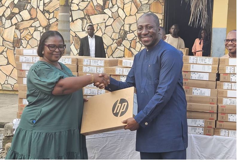 Mr Afenyo-Markin presenting a laptop to one of the beneficiaries