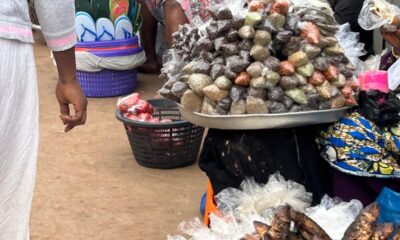 Some hawkers sitting behind their wares on the footbridge