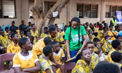 A volunteer with Rotary club assisting the pupils to read a book