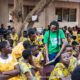 A volunteer with Rotary club assisting the pupils to read a book