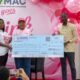 Ms Gozo (middle) receiving a cheque from the CEO of COMEC